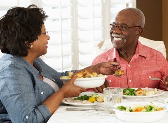 a mature couple with dentures enjoying a healthy meal