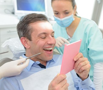man smiling while getting dental bridge in Falmouth