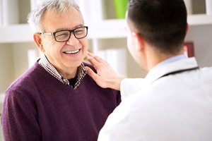 Patient talking with his Falmouth implant dentist