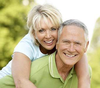 smiling senior couple with dental implants in Falmouth