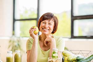 smiling woman holding an apple