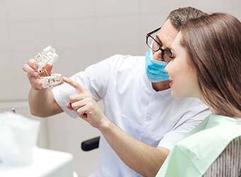 dentist showing a dental implant to a patient