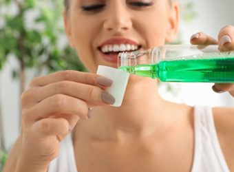 Patient pouring mouthwash in cap