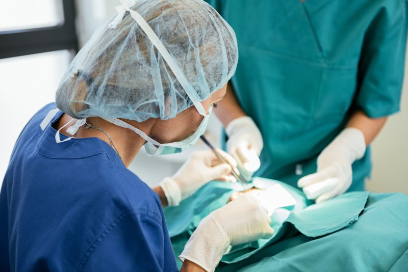 a dentist performing dental implant surgery on a patient