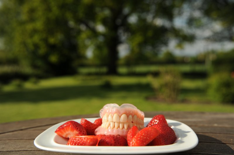 dentures on plate of strawberries