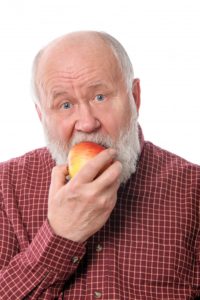 mature man biting into an apple 