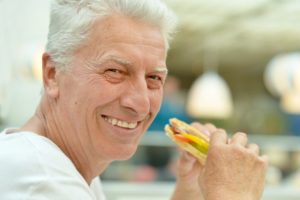 older man eating sandwich 