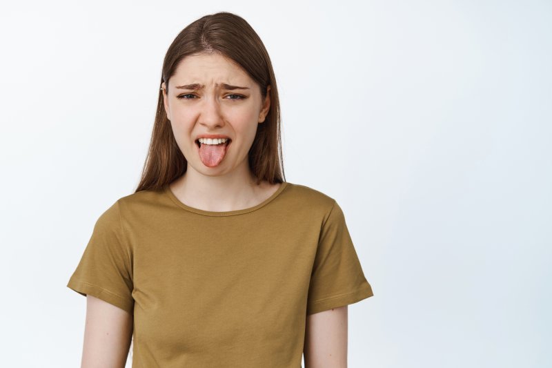 Woman sticks out tongue in disgust.