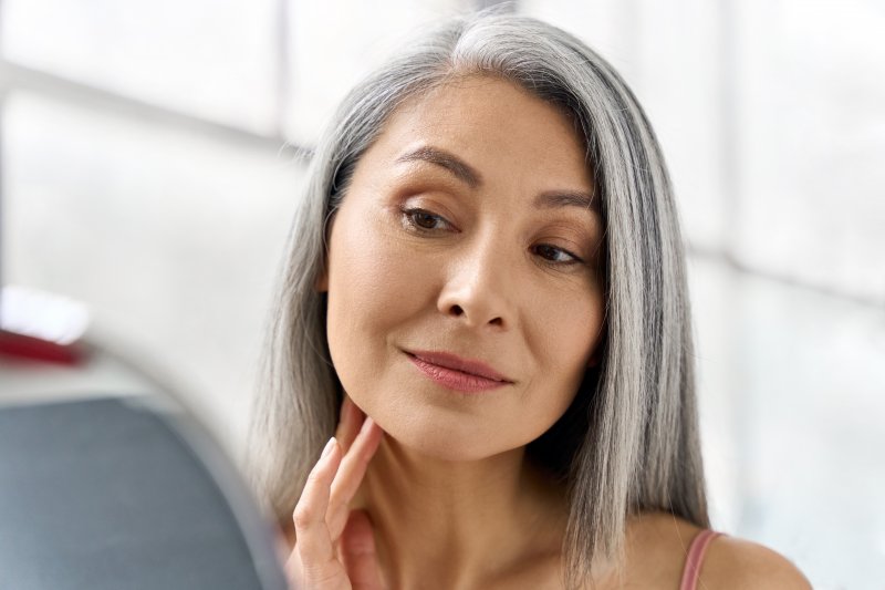 Patient looking into the mirror after getting dental implants