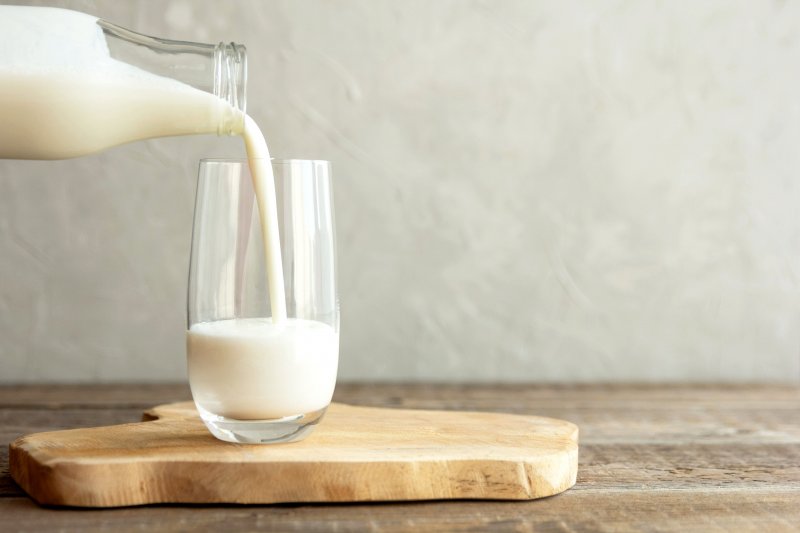 milk being pour from bottle into glass