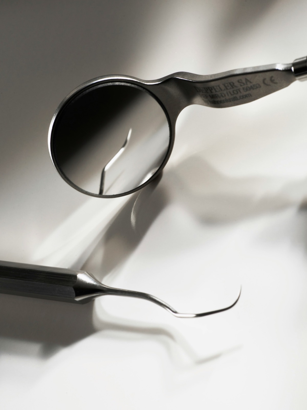 Close-up of a dental mirror and periodontal probe on a clean instrument tray