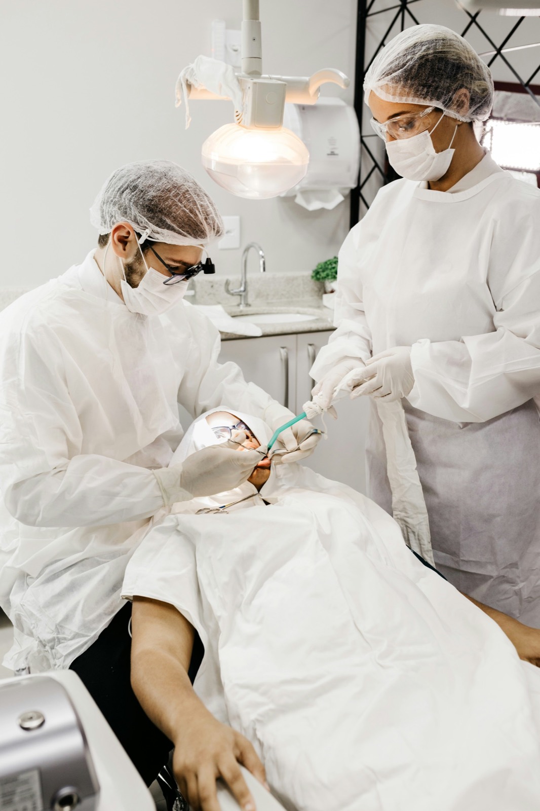 Dental team performing a procedure in full surgical protection