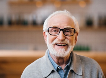Patient smiling confidently with implant-retained dentures at Casco Bay Smiles